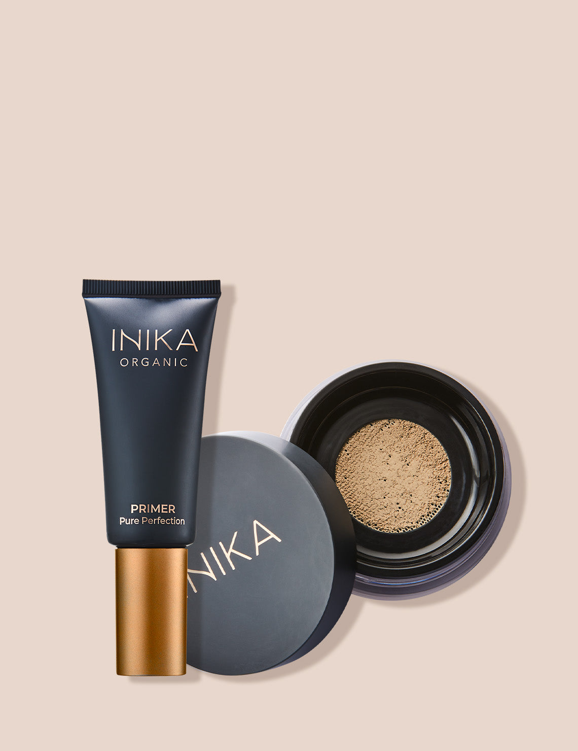 Cosmetic product set featuring Inika Organic primer and foundation on a beige background. Perfect for luxury beauty routines.